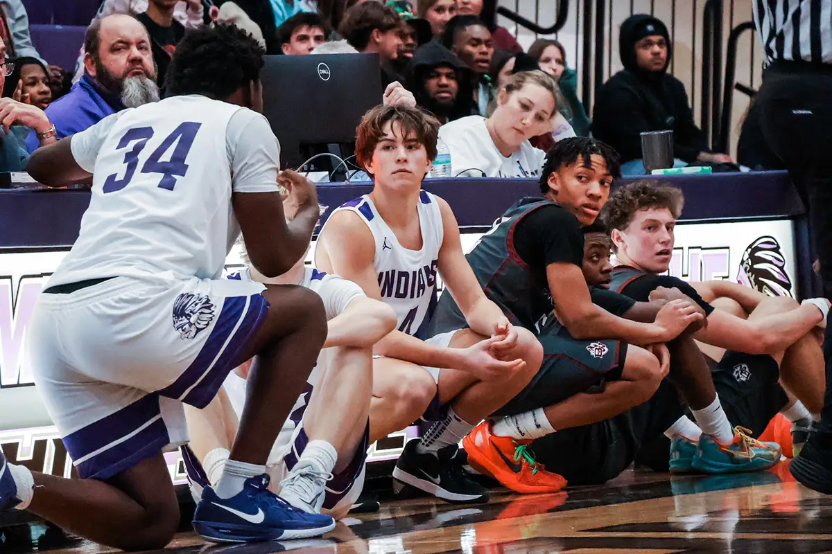 Basketball bench crouched on the sideline watching the game