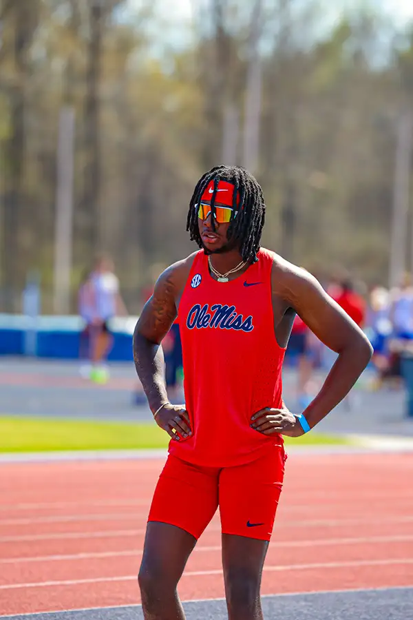 Sprinter in a red Ole Miss uniform standing on the track