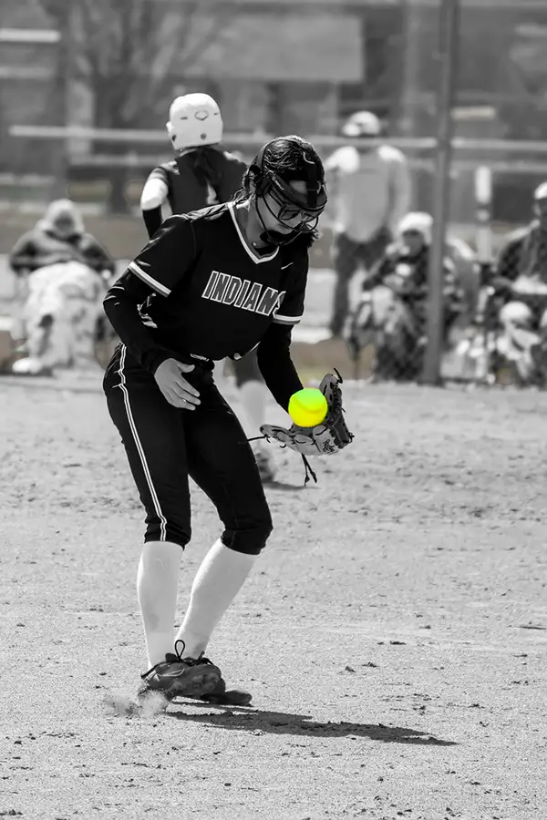 Black-and-white shot of a softball pitcher mid-delivery