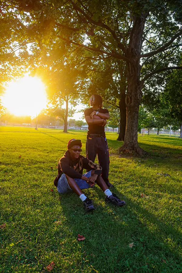 Two friends under a large tree at golden hour