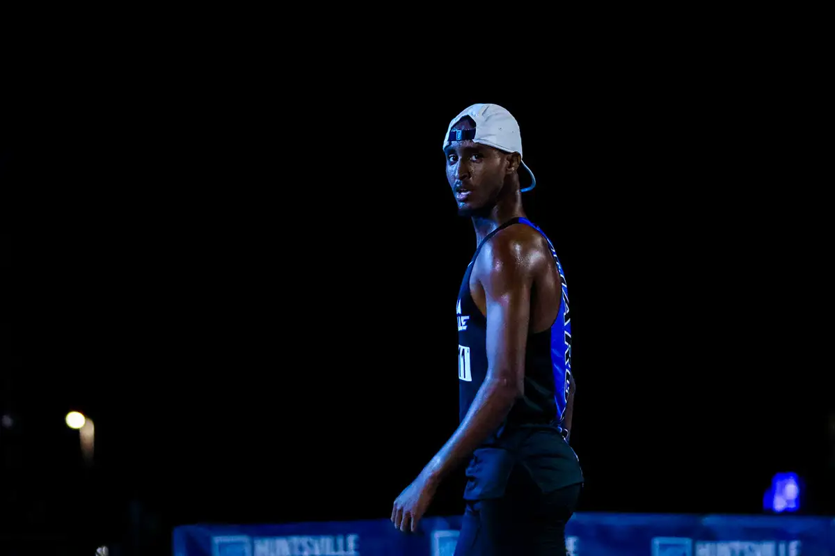 Athlete standing alone under a spotlight in a dark arena
