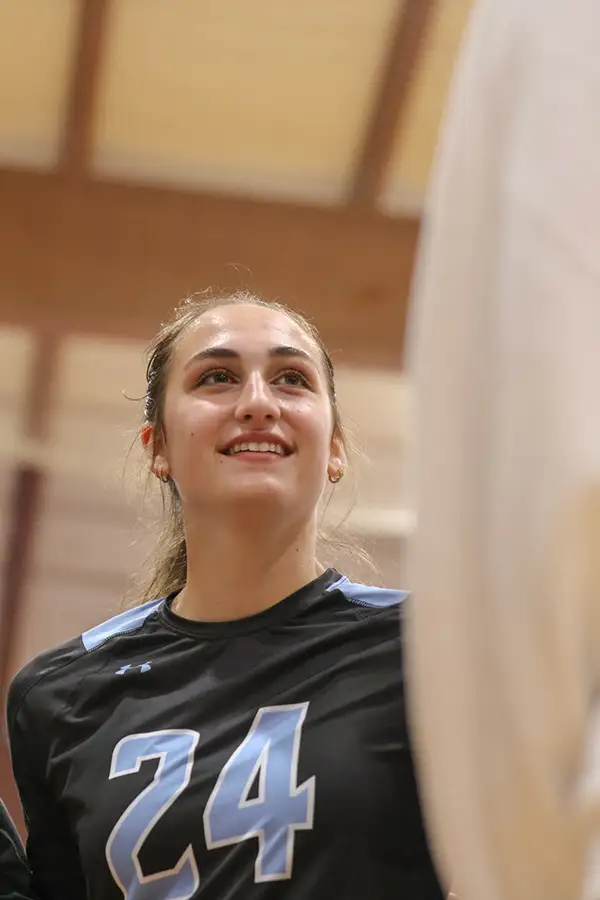Volleyball player in a number 24 jersey smiling toward the stands