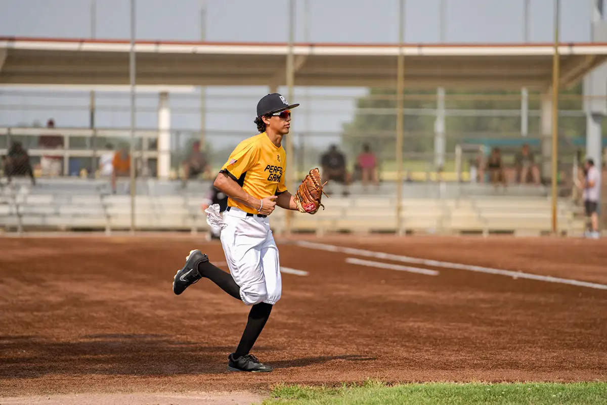 Baseball player in yellow running down the base line